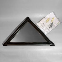 a triangle shaped object with some scissors on it's side and an advertisement in the background