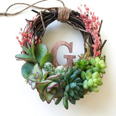 a wreath with the letter g on it and succulents