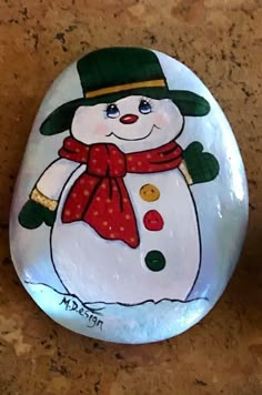 a rock with a snowman painted on it