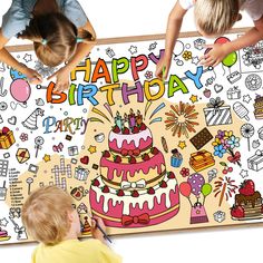 two children are drawing on a birthday card