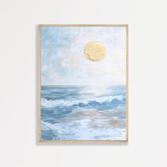 a painting hanging on the wall next to a white wall with a blue ocean and yellow moon