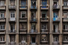 an apartment building with balconies and windows on each floor, in the city