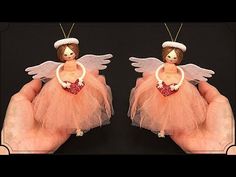 two handmade angel figurines in pink tulle with heart on black background