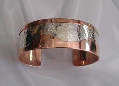 This Free Form Overlay bracelet is approximately one inch wide and has a smooth straight edge on one side and a free form wavy edge on the other side. The smooth surfaces of the copper and the hammer texture of the sterling silver center create a medley of color, texture and shapes. The slightly domed surface gives a look of fullness without the weight. NOTE: This particular bracelet has been sold. I will make you one like it in your size in about 2 weeks time. Select Small, Medium, or Large. or Elegant Silver-colored Copper Cuff Bracelet, Forged Jewelry, Hand Forged Jewelry, Sewing Tape Measure, Man Hand, Copper Cuff Bracelet, Copper Cuff, Crown Jewels, One Inch