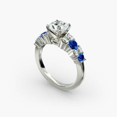 a diamond and blue sapphire engagement ring with three stone accents on the side, set in 18k white gold