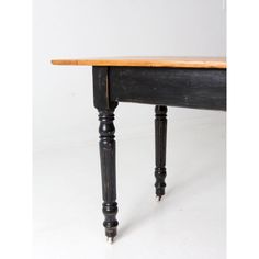 an old wooden table with black legs and wood top