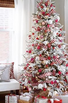 a white christmas tree with red and silver ornaments