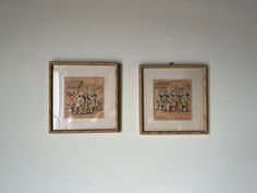 two framed pictures hang on the wall above a bed