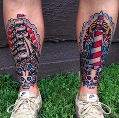 two people with tattoos on their legs standing in the grass