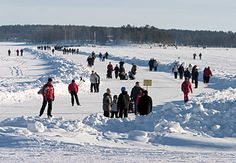 a group of people standing in the snow next to each other on a snowy field