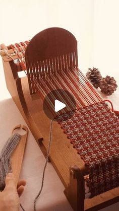 someone is weaving fabric on an old wooden loom