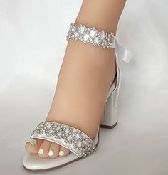 Our white wedding shoe, promises to cause waves amongst your wedding guests. Crafted in soft white leather and adorned with iridescent, light-catching rhinestones.  The luxurious leather lining is cushioned in all the right places to ensure ultimate comfort. Whilst the delicate straps and sturdy leather-wrapped block heel keep you feeling secure. You can wear them either with the leather ankle strap (Included)  or with the satin embroidered ribbon All of the embellishments are handsewn onto the Wedding Heels For Bride, Block Heels Wedding, Lace Up Block Heel, Heels Wedding, White Wedding Shoes, Leather Sandals Handmade, Leather Wedding, Womens Wedding Shoes, Rhinestone Bridal