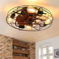 a light fixture in the middle of a living room with brick walls and flooring