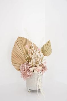 a vase filled with flowers and fan shaped decorations on top of a white countertop