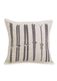 a black and white pillow with skis printed on the front, along with two pairs of ski poles