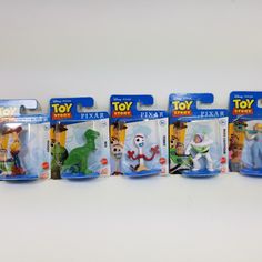 toy story figures are lined up on a white surface, with the packaging in different colors