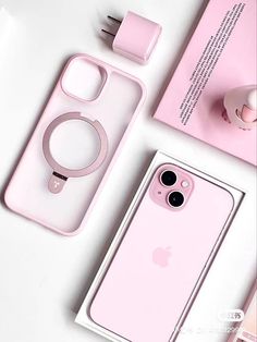 the pink iphone case is next to an earbud, charger and other accessories