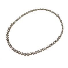 This pretty 1920s choker is a stylish piece perfect for layering.  Condition Report: Excellent The Details... This necklace is constructed from silver tone metal. Along its length, it is detailed with bezel set, round, colourless paste stones graduating in size. The necklace fastens with a box clasp and this is detailed with a larger paste stone. The necklace measures 34.5cm in length.  Wear it With... This elegant piece is ideal for layering with other Deco necklaces of varying lengths for a dr Classic Silver Necklace With Single Cut Diamonds, Classic Formal Diamond Choker Necklace, Silver Single Strand Tennis Necklace, Classic Silver Diamond Necklace For Party, Silver Diamond Necklace With 17 Jewels, Classic Formal Tennis Choker Necklace, Classic Tennis Choker Necklace For Formal Occasions, Classic Silver Rhinestone Round Necklace, Classic Silver Single Strand Diamond Necklace