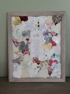 a wooden frame filled with lots of different types of paper hearts