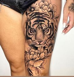 a woman's thigh with a tiger and flowers on it