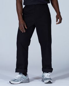 The Takibi Chino Pants are casual fire-resistant pants. The pants are made of cotton and modacrylic. The Takibi Chino Pants feature a button closure, dual side pockets, a coin pocket, and dual back pockets. The Takibi Chino Pants are designed to fit loose in the leg, with the hem hitting below the ankle. We recommend taking your normal size for a standard fit. The model stands 6' and wears size L.