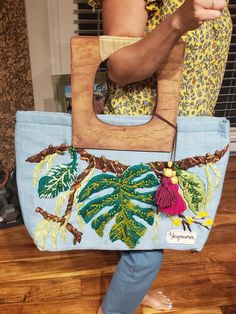 a woman carrying a handbag with an embroidered design on it