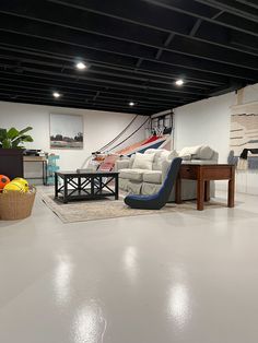 a living room filled with furniture and a large painting hanging on the wall behind it