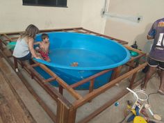 two children playing in an empty blue pool