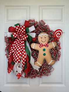 a christmas wreath with a gingerbread man and candy canes on the front door