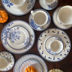 a table topped with plates and bowls filled with food next to small pumpkins on top of each plate