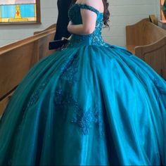 a woman in a blue ball gown standing next to a man