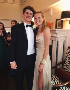 a man and woman in formal wear posing for a photo