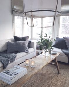 a living room with two couches and a coffee table in front of the window