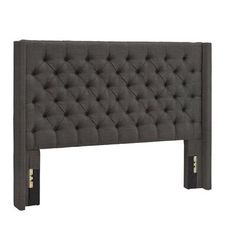 an upholstered headboard with buttons on the top and bottom, in grey fabric