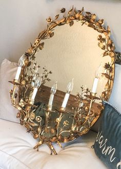 a mirror sitting on top of a bed next to pillows