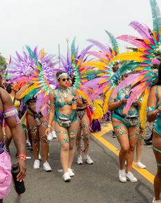 a group of women in colorful costumes walking down the street