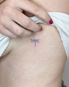 SIngle needle blue dragonfly tattoo located on the side Mini Tattoos Side Rib, Single Needle Dragonfly Tattoo, Damsel Fly Tattoo, Dragon Fly Tattoo Behind Ear, Blue Fine Line Tattoo, Dragonfly Hip Tattoo, Side Of Rib Tattoo, Damselfly Tattoo, Small Blue Tattoo