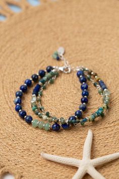 Indulge in the beauty of the sea with our Pacifica Collection! Each piece is meticulously handcrafted with stunning shades of blue, capturing the essence of ocean waves and clear skies. Sterling Silver (Lead & Nickel Free) Lapis Lazuli, Jasper, Aquamarine 7.5-8.5" adjustable with sterling silver lobster claw clasp We hand select our natural materials, thus there may be slight variations in color and/or size that will not detract from the overall aesthetic. Our unique handcrafted designer jewelry Blue Double Strand Bohemian Bracelets, Ocean-inspired Blue Strand Jewelry, Adjustable Blue Strand Jewelry, Blue Ocean-inspired Strand Jewelry, Blue Natural Stone Beach Bracelets, Blue Gemstone Beads Jewelry For Beach, Blue Natural Stone Bracelets For Beach, Blue Natural Stones Bracelets For Beach, Spiritual Blue Beaded Bracelets For Beach