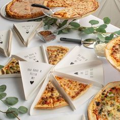 a table topped with pizza slices covered in toppings next to other pies and plates