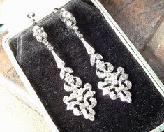 "Offering a beyond exquisite pair of vintage Art Deco pave rhinestone flapper long pendant dangle earrings. These look like they are right off the set of \"Downton Abbey\" and will be the perfect \"Something Old\" for the Bride and with a pair of jeans and a tee afterwards. Photos do not capture the sparkle adequately! The circa 1930 - 1940 ornate silver rhodium plated earrings are pave set with baguette cut as well as tiny round cut brilliantly clear sparkly crystal rhinestones. Earrings are de Vintage Silver Bridal Earrings For Evening, Vintage Silver Chandelier Earrings For Wedding, Silver Vintage Chandelier Earrings For Wedding, Vintage Bridal Earrings With Intricate Design, Vintage Bridal Earrings With Intricate Design For Formal Occasions, Victorian Earrings With Diamond Accents For Wedding, Victorian Wedding Earrings With Diamond Accents, Vintage Dangle Bridal Earrings, Vintage Bridal Earrings For Wedding