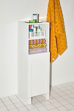 a white cabinet with towels and other items on it