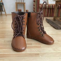 a pair of brown boots sitting on top of a wooden floor