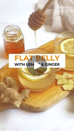 a wooden cutting board topped with sliced lemons and ginger next to a jar of honey