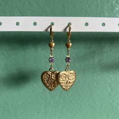 16k gold filled Huggie hoop earrings with mini brass hearts and large flower stamped hearts. Vintage light purple Swarovski and 14k gold filled findings. Nickel-free Gold Heart-shaped Jewelry, Nickel Free Heart-shaped Brass Jewelry, Nickel Free Gold Heart Shaped Jewelry, Nickel-free Gold Heart Jewelry, Nickel-free Gold Heart Shaped Jewelry, Nickel Free Brass Heart-shaped Jewelry, Nickel-free Heart-shaped Brass Jewelry, Nickel Free Heart Shaped Brass Jewelry, Yellow Gold Earrings With Heart Charm