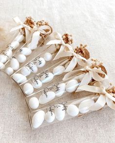 four white seashells wrapped in twine and tied with ribbon on top of each other