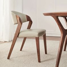 two chairs sitting next to each other on top of a carpeted floor in front of a white wall