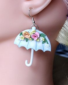 Introducing our stunning Umbrella Earrings, the perfect whimsical gift for her! These handmade earrings are an ideal gift for your wife or even for back to school teacher appreciation. With delicate floral details, these unique earrings add a touch of elegance to any outfit. Whether it's a unique birthday gift or just a little something to brighten her day, these beautiful earrings are sure to be cherished. Shop now for this one-of-a-kind piece of weather jewelry that will surely make her heart skip a beat.   These spring earrings are lovingly handcrafted with a unique design, making them a great addition to any  jewelry collection. They'll be sure to be noticed and make any outfit pop. Give these cute dangle earrings as a thoughtful present to a special teacher to show your appreciation. Handmade Charming Earrings For Gift, Charming Earrings For Pierced Ears As Gift, Charming Handmade Earrings For Gift, Charming Earrings As A Gift, Whimsical Polymer Clay Earrings For Gift, Whimsical Polymer Clay Earrings As Gift, Whimsical Handmade Earrings For Everyday, Whimsical Everyday Drop Earrings Jewelry, Whimsical Adjustable White Earrings