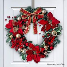 a christmas wreath with poinsettis and bells hanging on a white front door