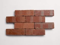 a brick wall made out of red bricks on a white surface with no one in it