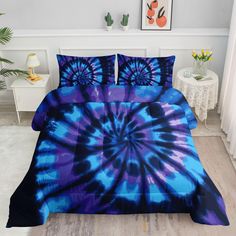 a bed with blue and purple tie - dyed comforters